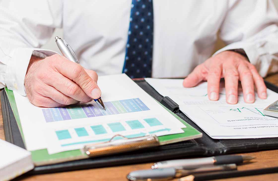 Businessman writing on accounting documents