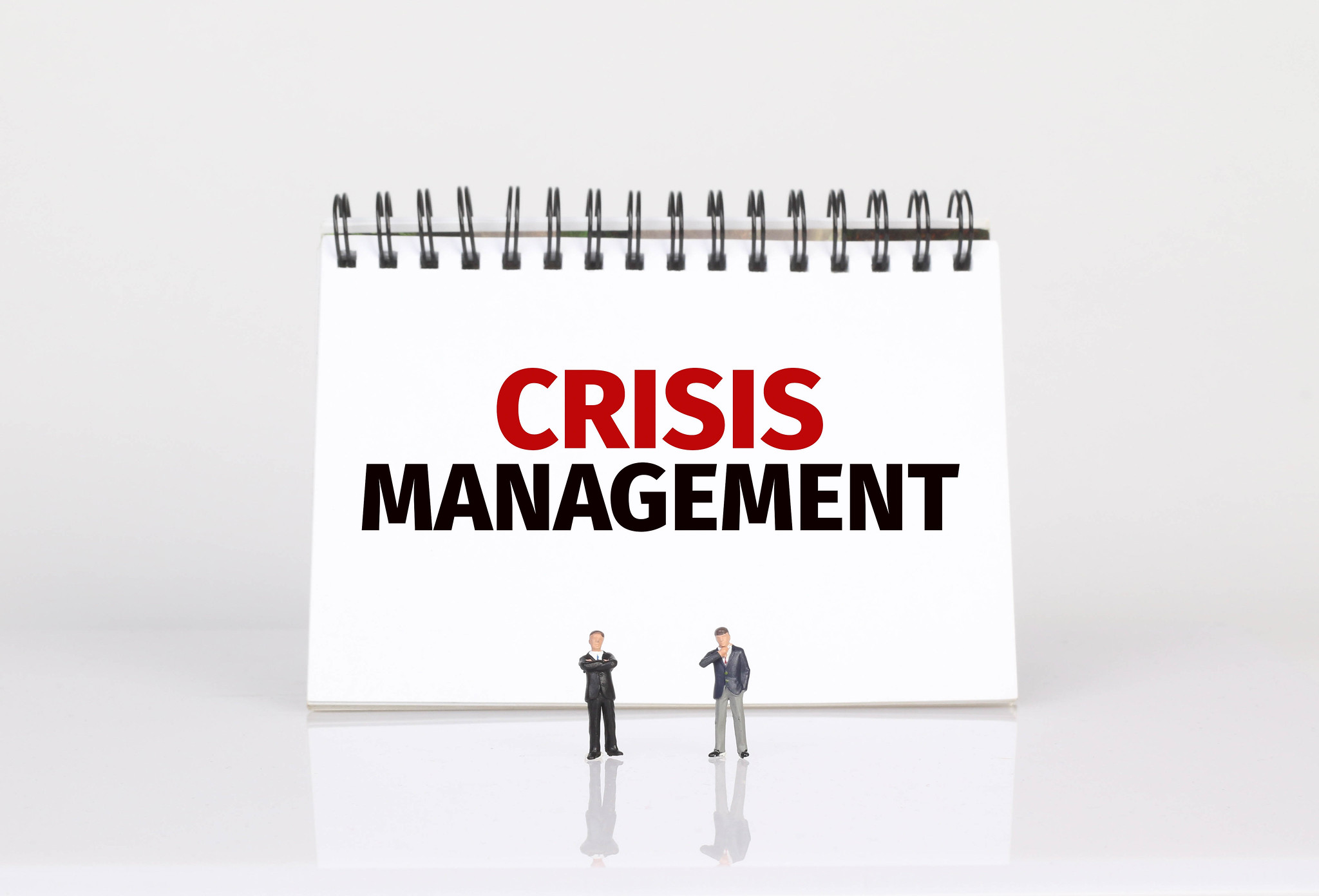 Two men plan CFO crisis management near a calendar showing "Crisis Management."